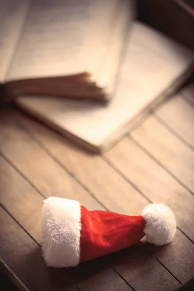 Santa Claus Christmas hat and old books — Stock Photo, Image