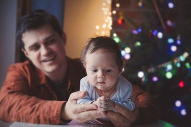 Genç yardım için bir küçük çocuk yalan karın üzerinde ilk kez baba. Bebek odaklı kapalı görüntü