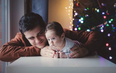 Genç yardım için bir küçük çocuk yalan karın üzerinde ilk kez baba. Bebek odaklı kapalı görüntü