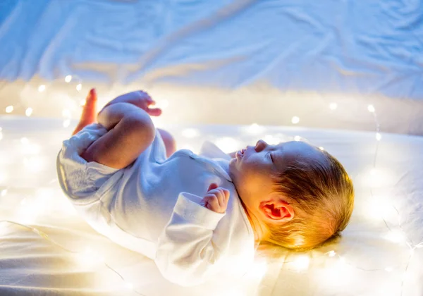 Işıkların Beyaz Yatakta Küçük Bebek — Stok fotoğraf
