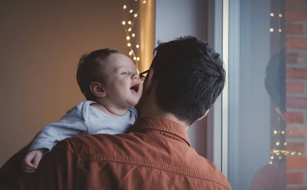 若い父親の肩に小さな子供を保持します 幼児に焦点を当てると屋内の画像 — ストック写真