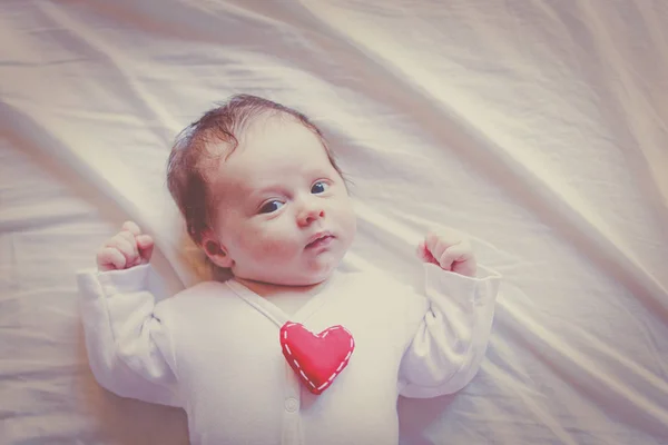 Criança Pequena Com Brinquedo Forma Coração Peito Deitado Fundo Branco — Fotografia de Stock