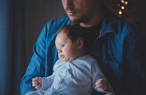 窓の近くの父の手の中の小さな幼児の写真 自然光で作られたイメージ — ストック写真
