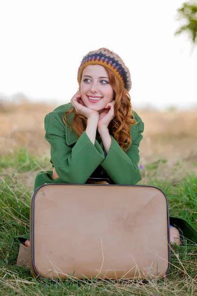 Портрет Молодой Женщины Зеленом Пальто Чемоданом Сидящей Траве Открытом Воздухе — стоковое фото