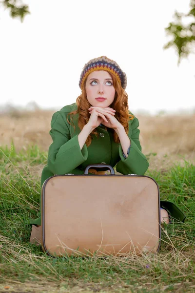 Çimlere Oturup Kırsal Açık Bavul Ile Yeşil Paltolu Genç Kadın — Stok fotoğraf
