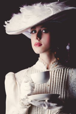 İle çay siyah arka plan üzerine beyaz Victoria dönemi giysili genç Kızıl saçlı kadın.