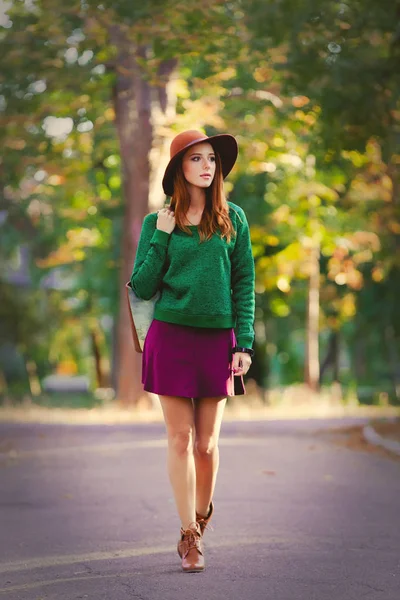 秋天公园室外的年轻红头发的妇女与袋子和帽子 — 图库照片