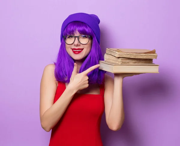 紫の髪と紫の色の背景上の本若いスタイルの流行に敏感な女の子の肖像画 — ストック写真