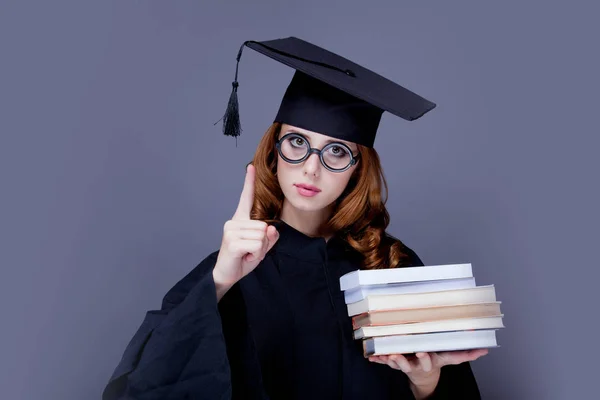 Junge Rothaarige Absolventin Quadratischer Akademischer Mütze Und Mantel Mit Büchern — Stockfoto