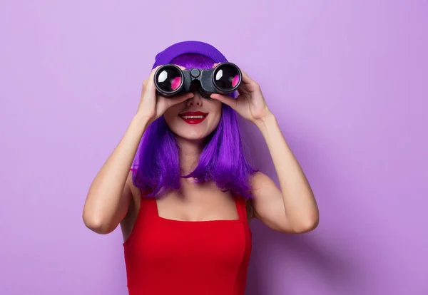 蓝色头发和双筒望远镜的年轻时髦女孩的肖像在紫色背景 — 图库照片