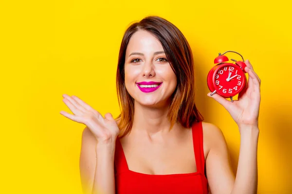 Girl in red dress with red alarm clock — Stock Photo, Image