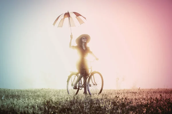 Ragazza con ombrello in sella ad una bici — Foto Stock
