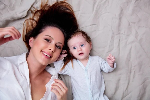 Madre y un niño pequeño acostados —  Fotos de Stock