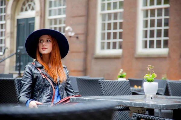 Młoda ruda dziewczyna w kapeluszu w kawiarni w Amsterdam — Zdjęcie stockowe