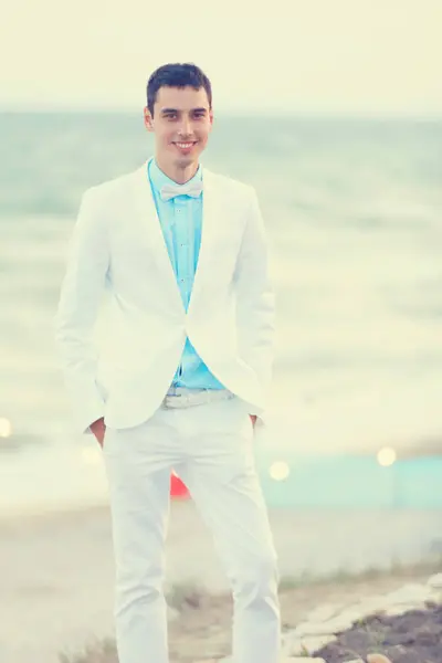 Young bridegroom in white clothes at sea cost — Stock Photo, Image