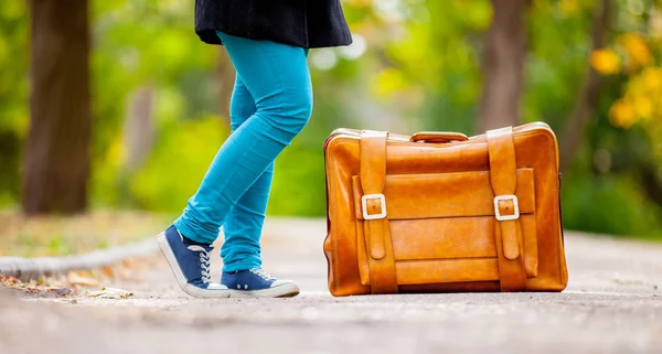 Подростковые ноги с чемоданом — стоковое фото