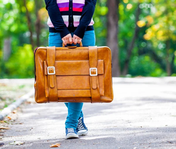Giovane ragazza cintura con valigia in un parco — Foto Stock