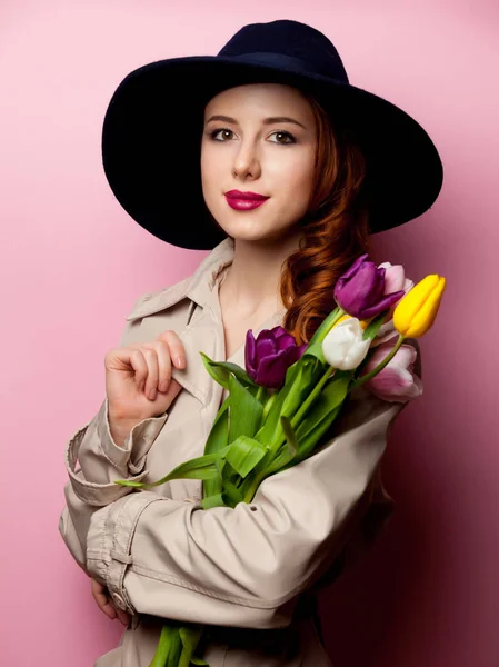 Žena v plášti s kyticí tulipánů — Stock fotografie