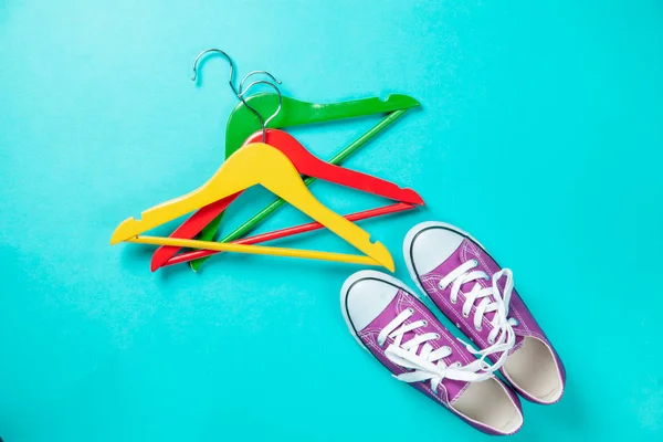 Hanger and gumshoes on blue background — Stock Photo, Image