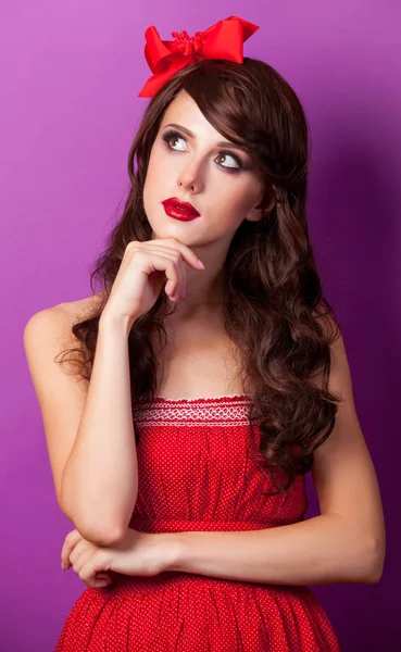 Portret van brunet meisje in de rode jurk en boog — Stockfoto