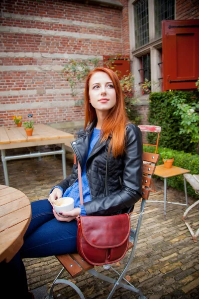 Chica pelirroja joven en sombrero en un café en Amsterdam — Foto de Stock