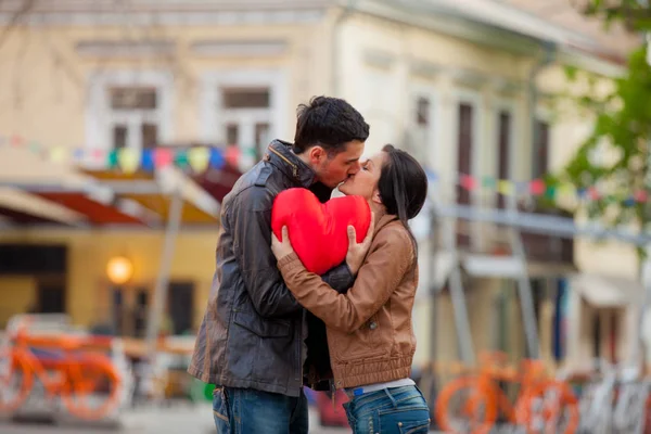 Young couple with heart shape toy kissing — Stock Photo, Image