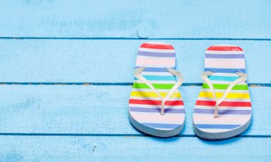 Renkli flip ayakkabı üzerinde mavi ormanlara floplar. 