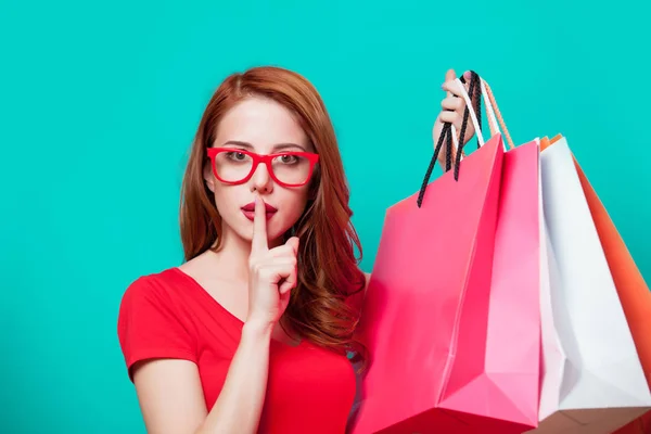 Young beautfiul redhead girl in eyeglasses with shopping bags — Stock Photo, Image