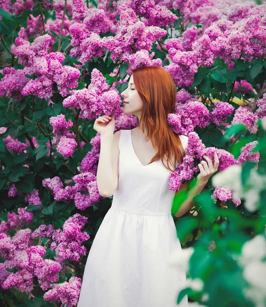 Young Redhead Girl White Dress Standing Lilac Bushes Park Springtime — Stock Photo, Image