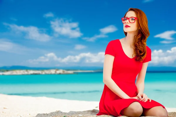 Meisje in rode jurk op het strand — Stockfoto