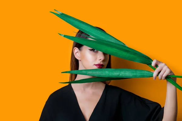 Vacker Kvinna Mörka Kläder Med Palmblad Gul Färgbakgrund — Stockfoto