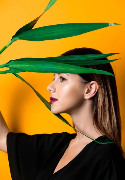Vacker Kvinna Mörka Kläder Med Palmblad Gul Färgbakgrund — Stockfoto
