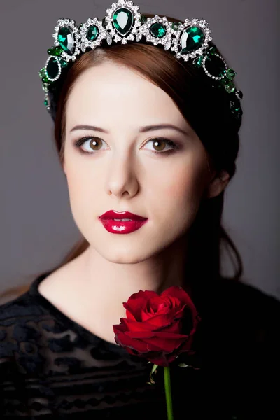 年轻红头发的女孩与皇冠和玫瑰灰色背景 — 图库照片