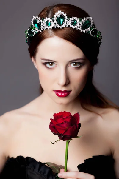 年轻红头发的女孩与皇冠和玫瑰灰色背景 — 图库照片