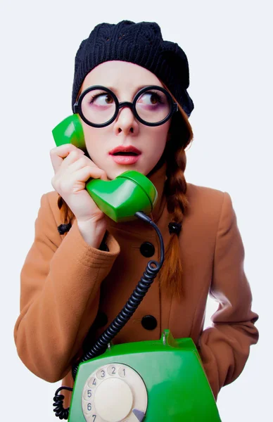 一个年轻的红发滑稽的书女孩的肖像与眼镜和大衣在白色背景电话交谈 — 图库照片