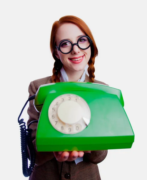 一个年轻的红头发教师的肖像与圆形眼镜和绿色拨号电话在白色背景 — 图库照片