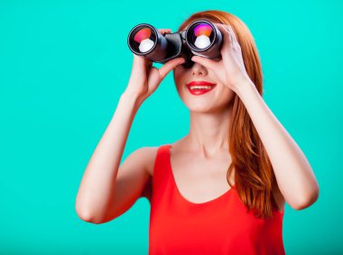 Nane arka plan üzerinde dürbün ile genç Kızıl saçlı kız 