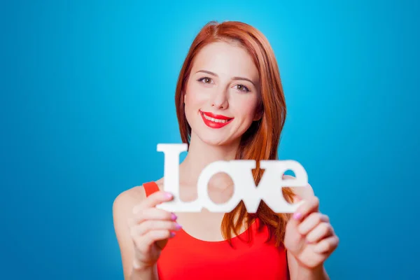 Kızıl Saçlı Kız Mavi Arka Plan Üzerinde Kelime Aşk Ile — Stok fotoğraf