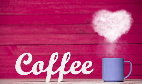 ハート型紫一杯のコーヒーから蒸気し ピンク色の背景上のコーヒーの単語 — ストック写真