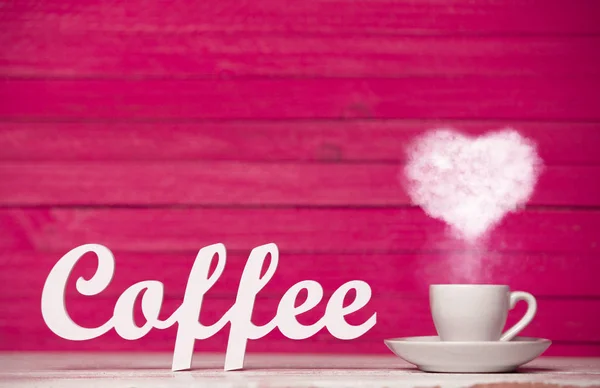 ハート ベージュ一杯のコーヒーから蒸気し ピンク色の背景上のコーヒーの単語 — ストック写真