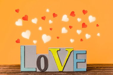 Metin sevgi ve kalp şekillerin çevresinde ahşap arka plan üzerinde