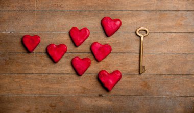 Metal anahtar ve kalp kurabiye ahşap arka plan üzerinde şekil 