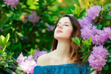 Kızıl saçlı kız çiçeği bush çiçekler ilkbaharda poz 