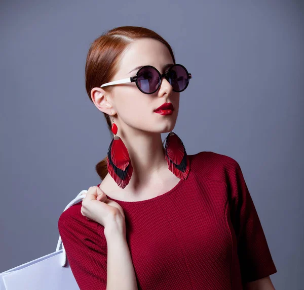 Portret Młodej Kobiety Czerwonej Sukience Okulary Przeciwsłoneczne Torbą Zakupy Pozowanie — Zdjęcie stockowe