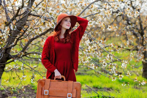 Roodharige Meisje Rode Kleding Hoed Met Koffer Cherry Blossom Tuin — Stockfoto