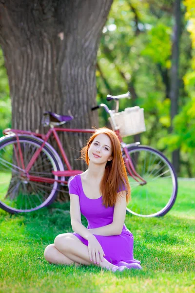 Młoda Ruda Dziewczyna Siedzi Trawie Pobliżu Vintage Rower Tle Latem — Zdjęcie stockowe