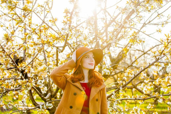 Roodharige Meisje Hoed Poseren Staande Cherry Blossom Tuin — Stockfoto