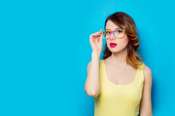 Rothaarige Mädchen Gelbem Kleid Und Farbiger Brille Auf Blauem Hintergrund — Stockfoto