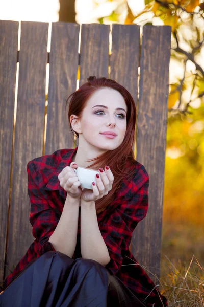 Ragazza Rossa Con Tazza Seduta Sull Erba Nel Giardino Autunnale — Foto Stock