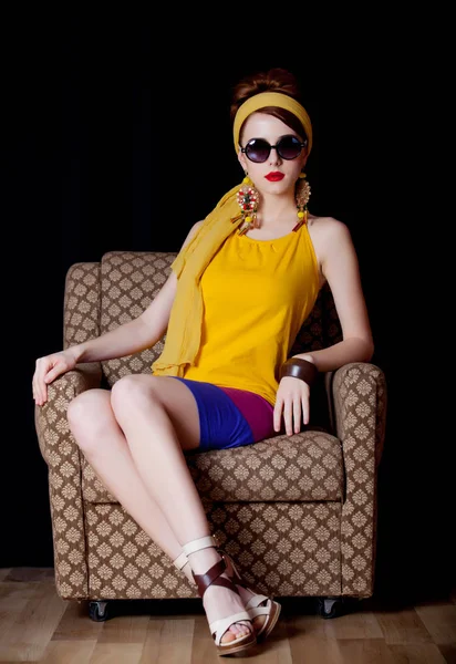 70S 衣服风格的年轻红发女孩坐在椅子上黑色背景 — 图库照片